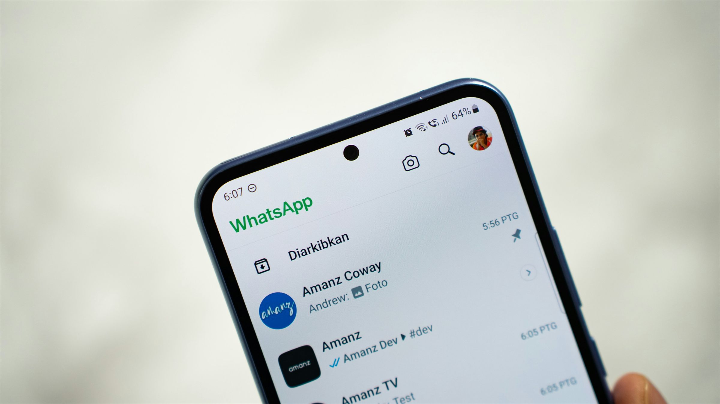 A phone showing a WhatsApp chat list